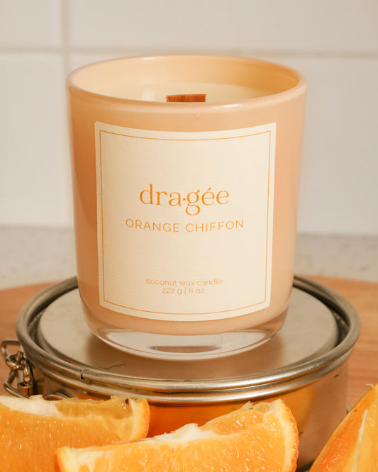Orange candle with white label says Orange Chiffon from Dragee Candle Company. In kitchen.